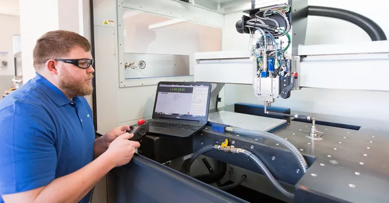 worker sitting at a machine learning how to become a cnc machinist
