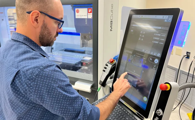 a cnc machinist on a machine demonstrating what a cnc machinist is